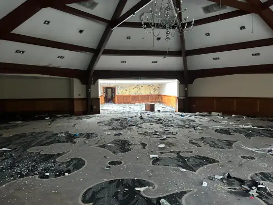 Empty function hall with chandelier at the abandoned Airth Castle and hotel complex.