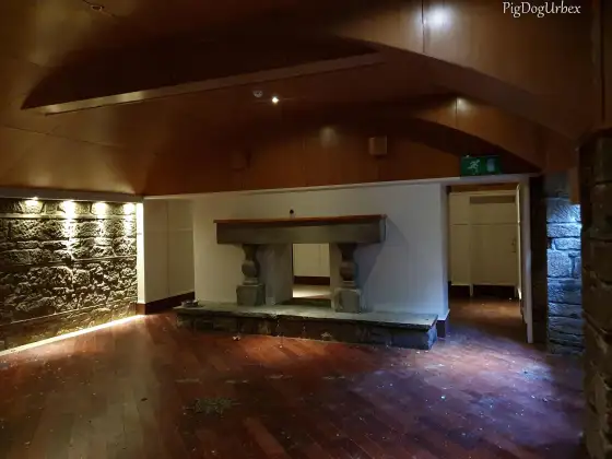 Empty stone-walled room with fireplace at the abandoned Airth Castle and hotel complex.