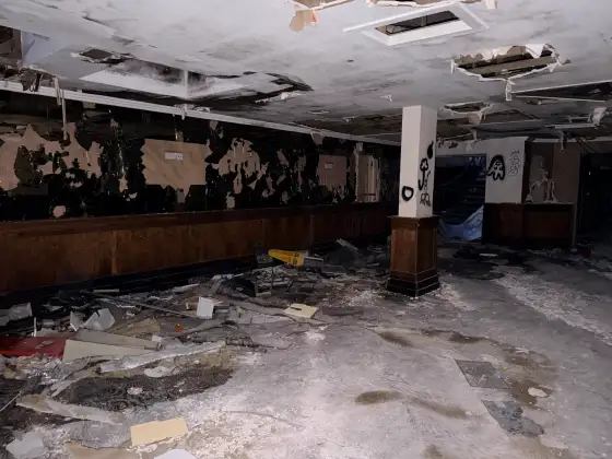 Shattered mirrors, ceiling holes and rubble in a wood-panelled hotel room.